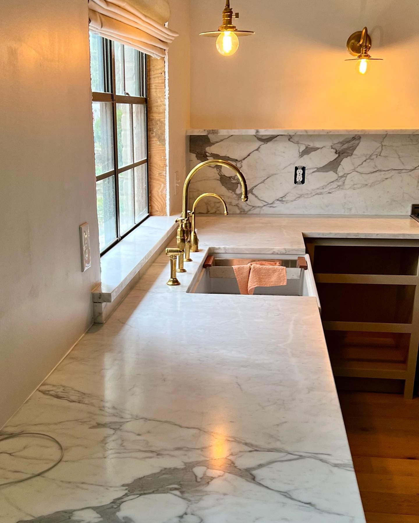 A kitchen with marble counter tops and a sink
