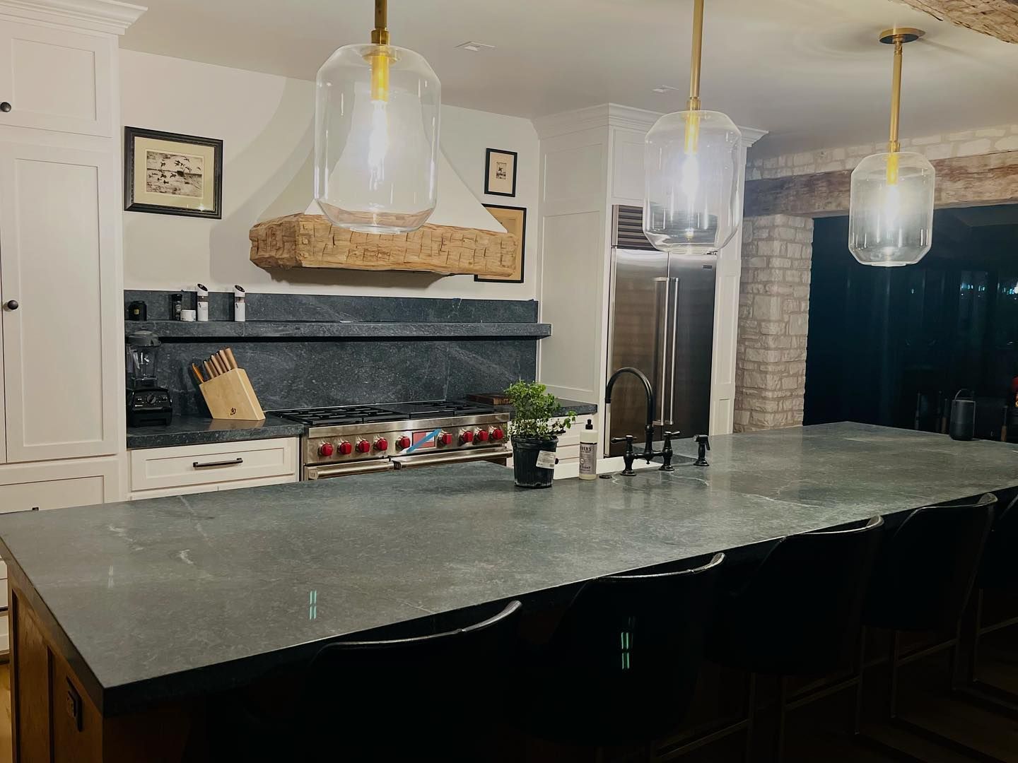 A kitchen with a large island and a stove top oven.