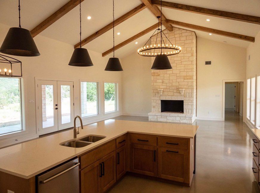 A kitchen with a sink , dishwasher , and fireplace.