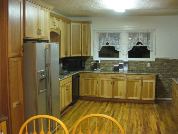 A kitchen with wooden cabinets and a stainless steel refrigerator