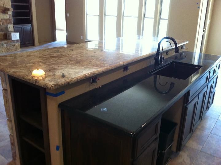 A kitchen with granite counter tops and a black sink