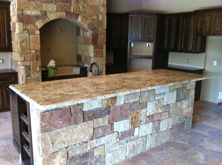 A kitchen with a large island and a stone fireplace