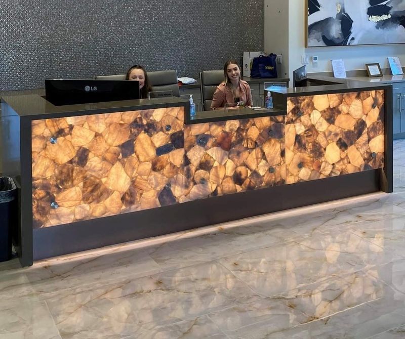 Two women are sitting at a reception desk in a lobby.