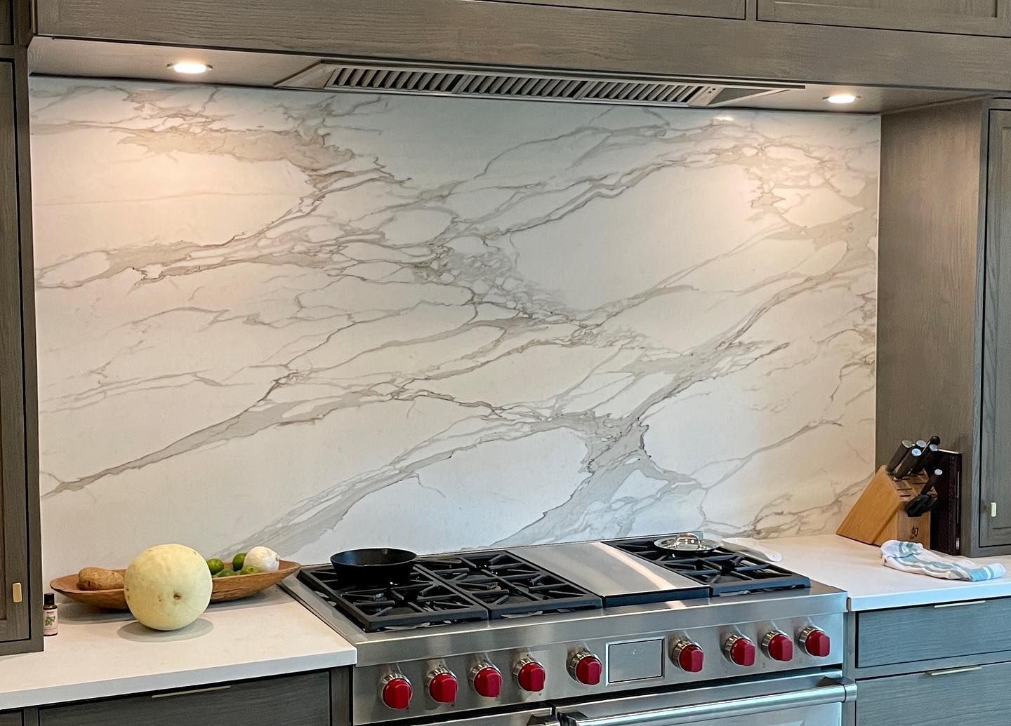 A kitchen with a stove top oven and a marble counter top.