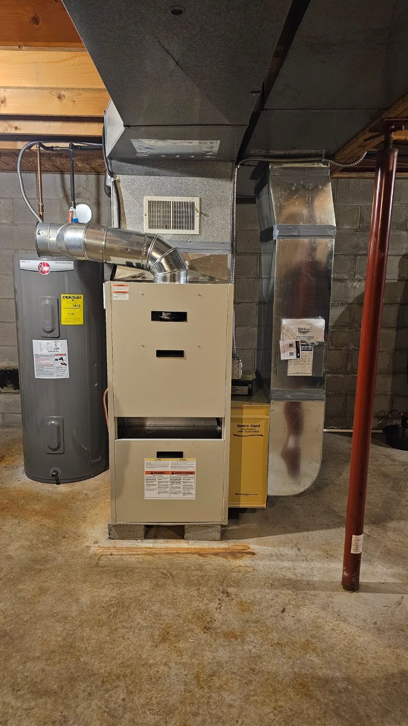 A basement with a furnace , water heater , and air conditioner.