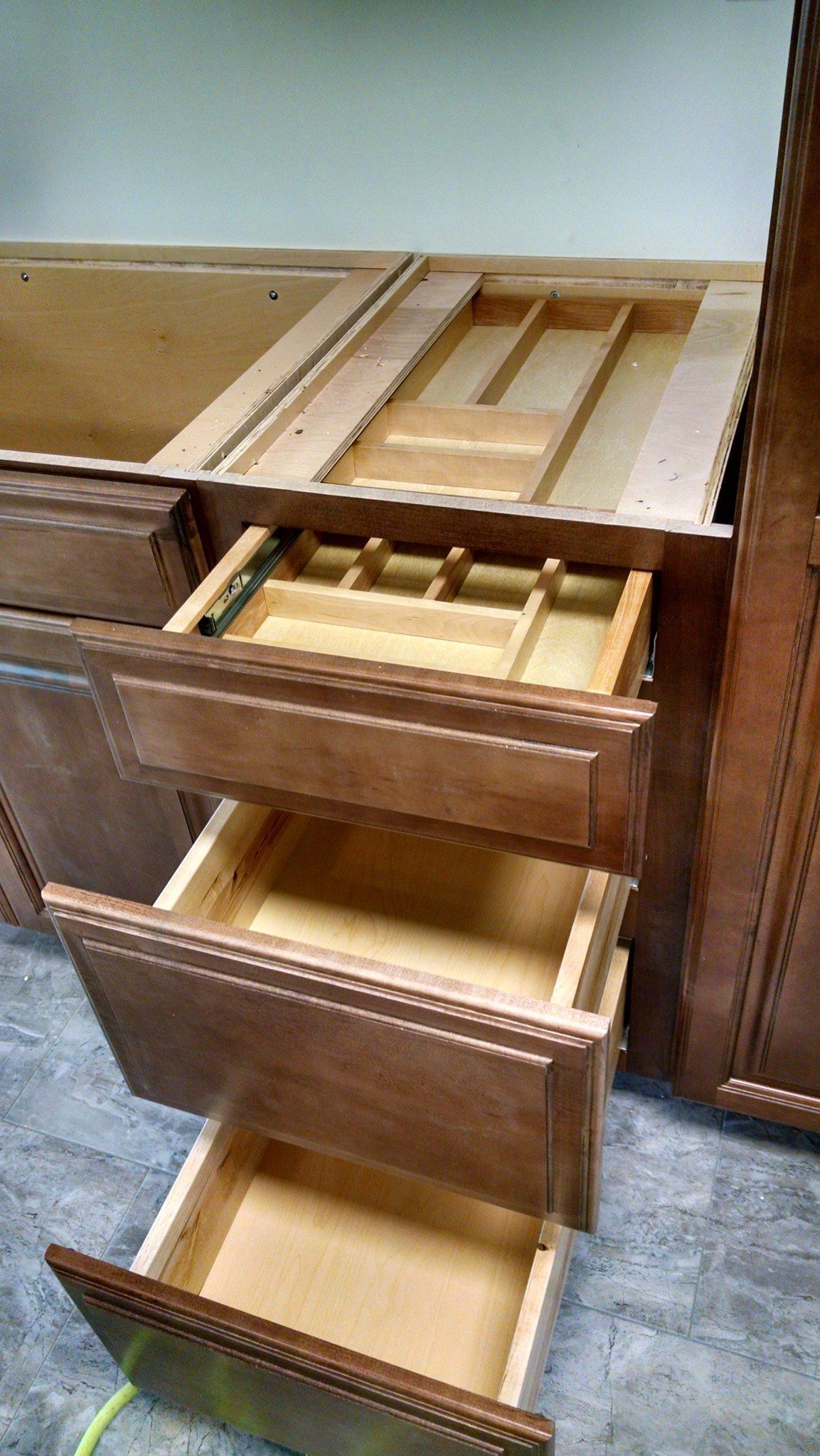 A close up of a kitchen cabinet with drawers open.
