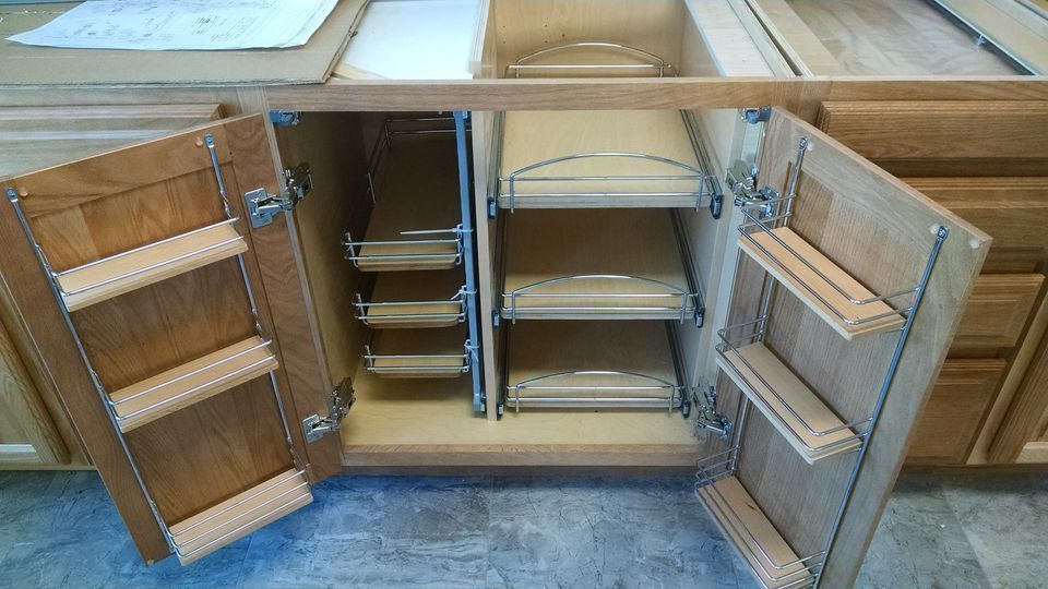 A kitchen cabinet with the doors open and shelves.