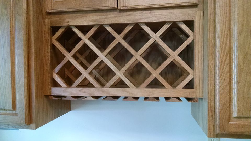 A close up of a wooden wine rack in a kitchen.