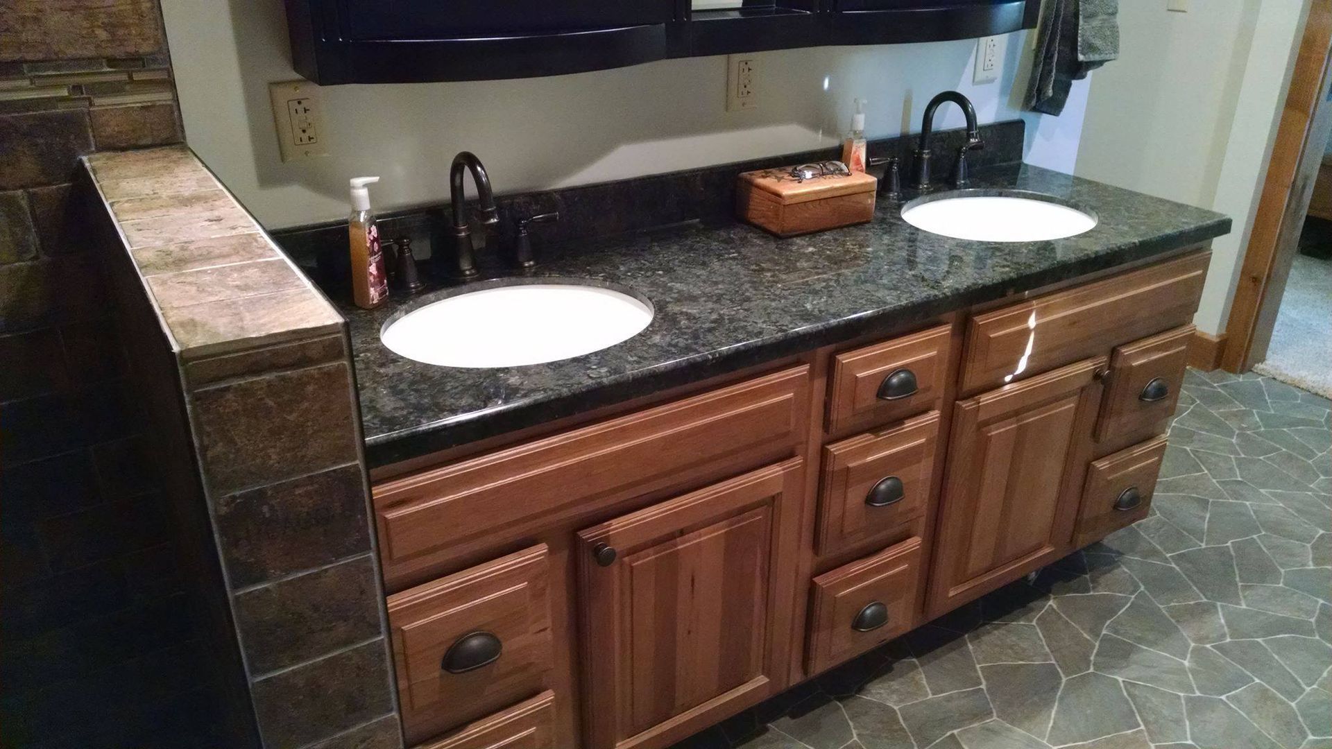 A bathroom with two sinks and wooden cabinets