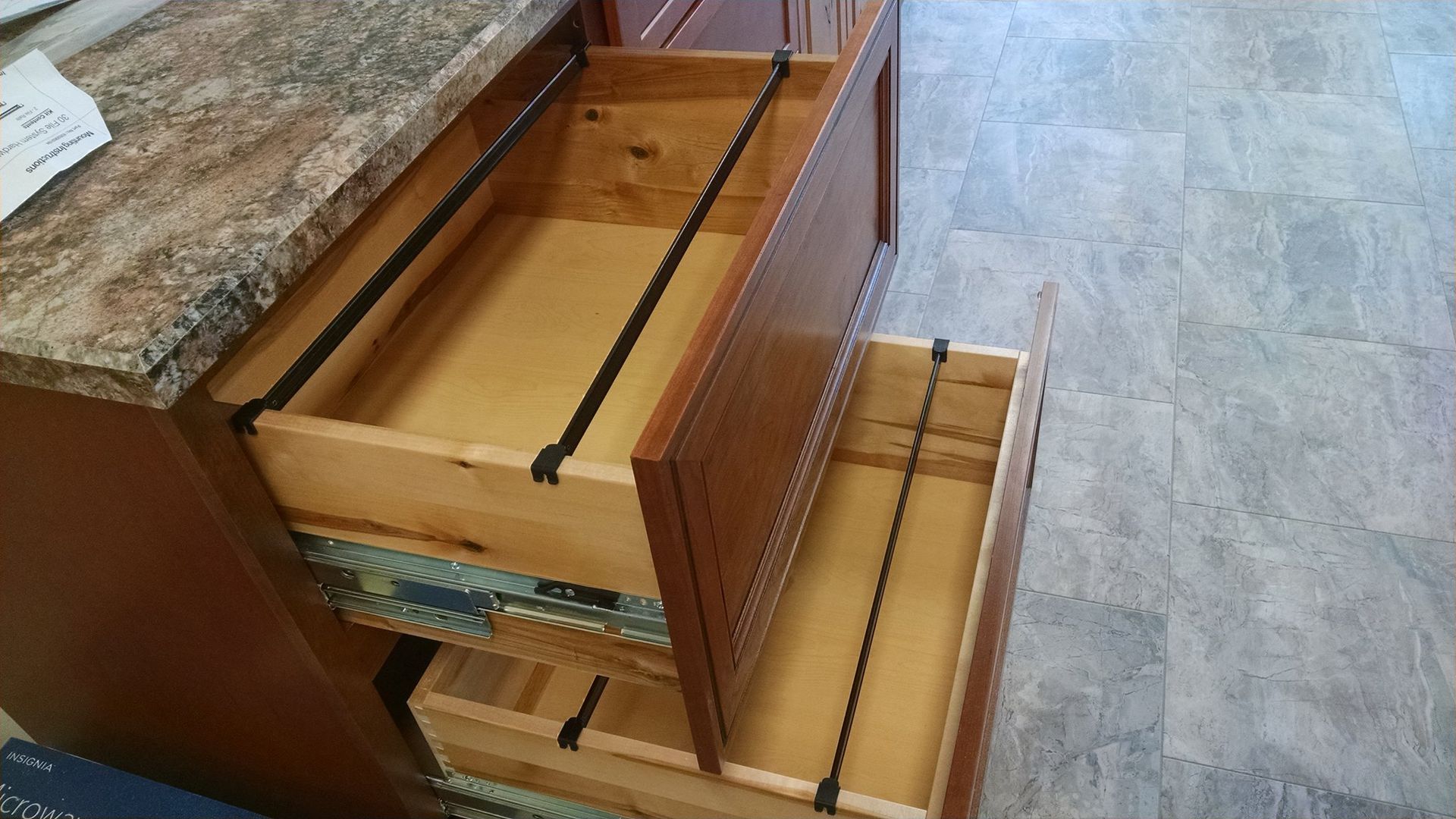 A close up of a wooden drawer with a metal railing.