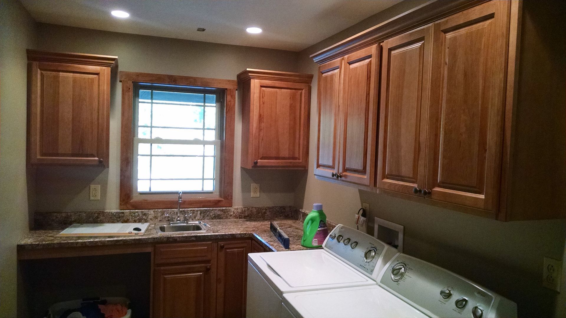 A laundry room with wooden cabinets and a washer and dryer