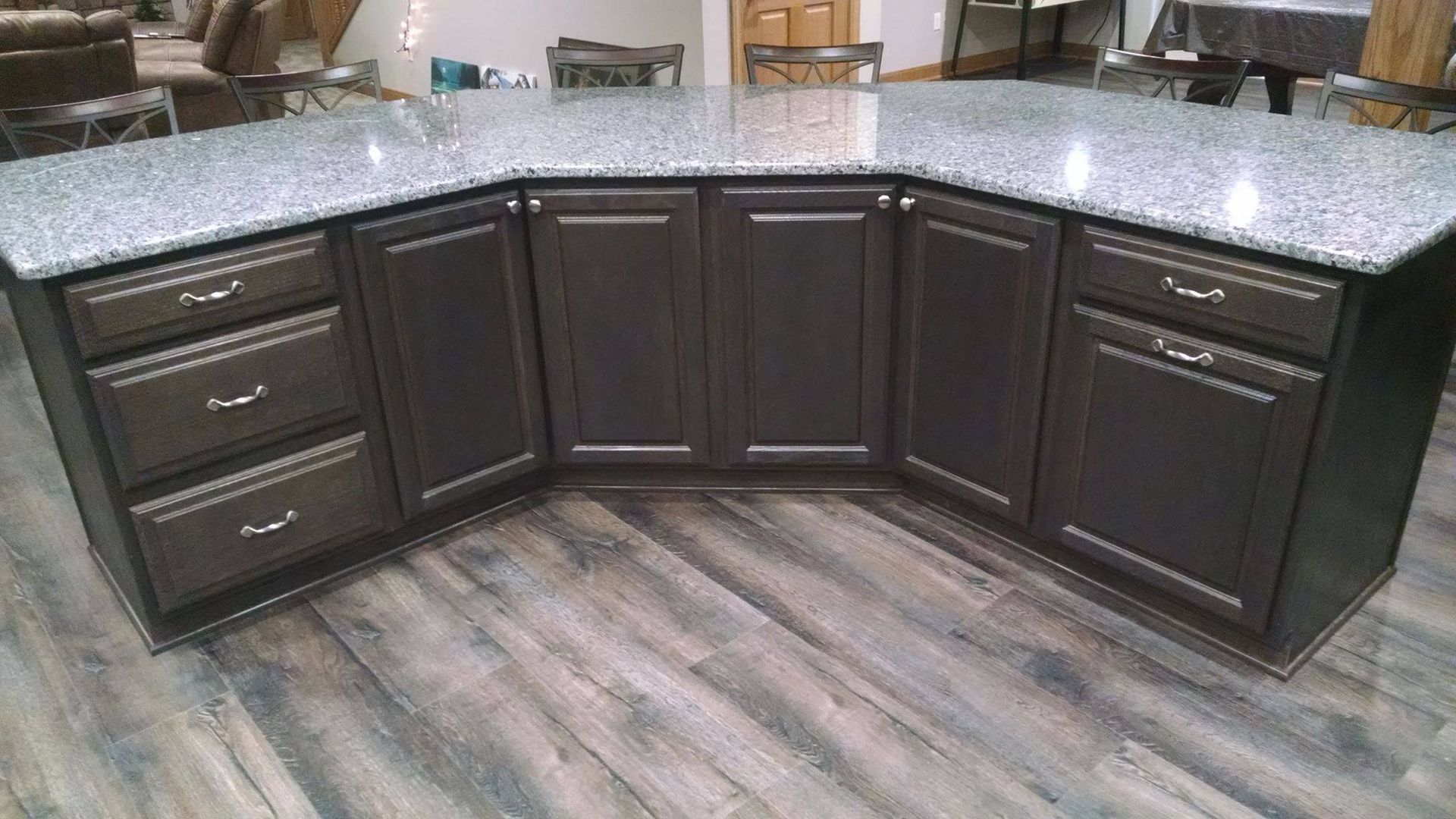 A kitchen with black cabinets and granite counter tops.