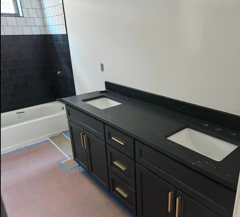 A bathroom with black cabinets and two sinks
