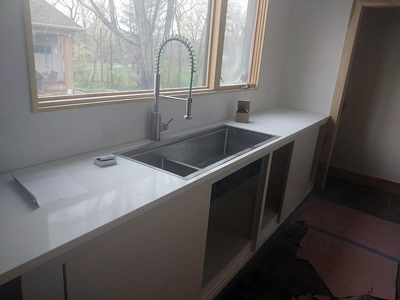 A kitchen with a stainless steel sink and a window.