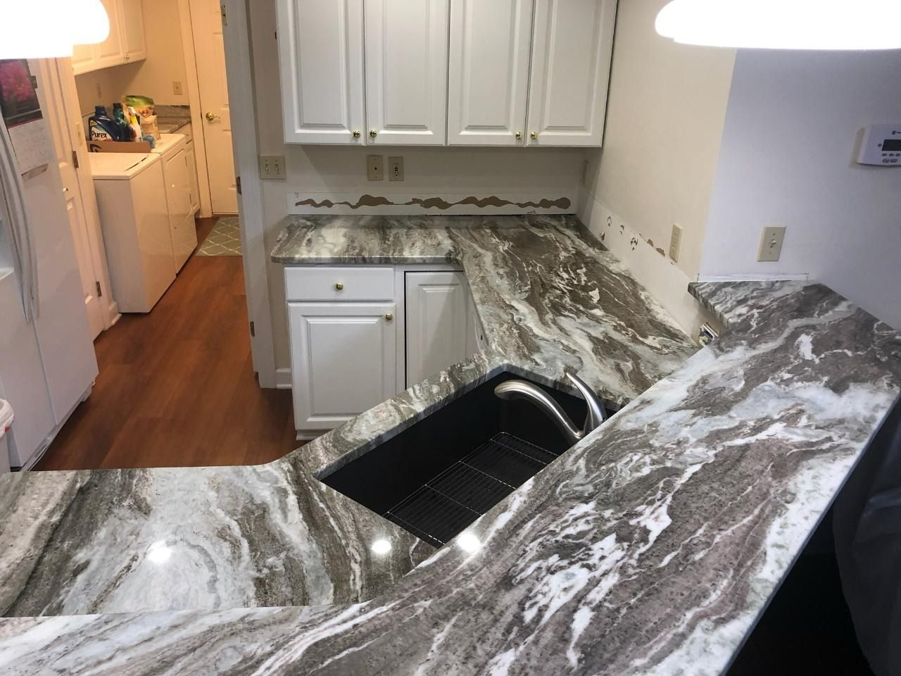 A kitchen with marble counter tops and a sink.