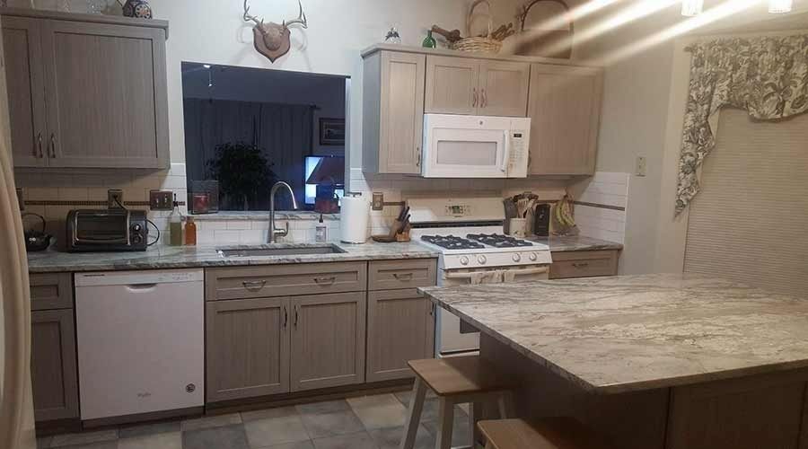 A kitchen with a stove , sink , microwave and dishwasher.