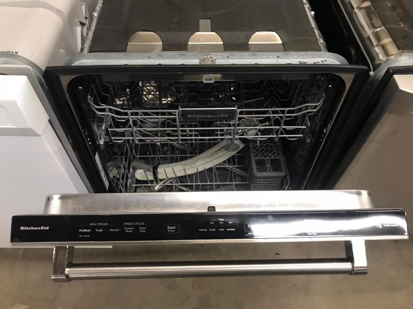 Open KitchenAid dishwasher with stainless steel interior and control panel.