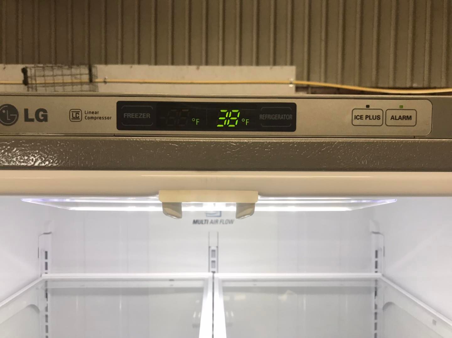 LG refrigerator with an empty interior. The digital display shows 39°F.