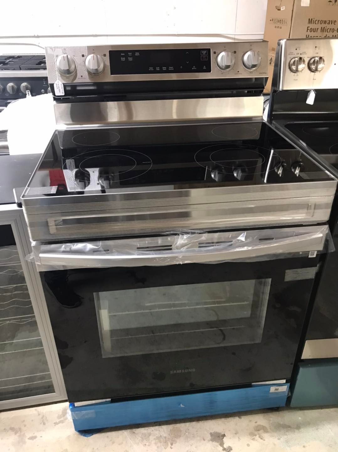 Stainless steel electric range with black cooktop and oven door.