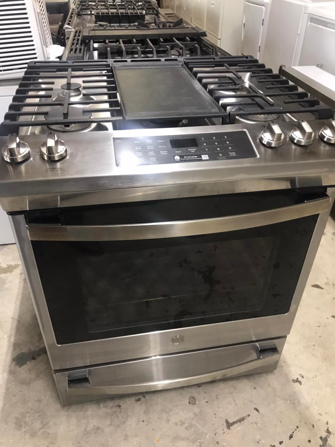Stainless steel gas range with cooktop and oven; indoor, close-up shot.