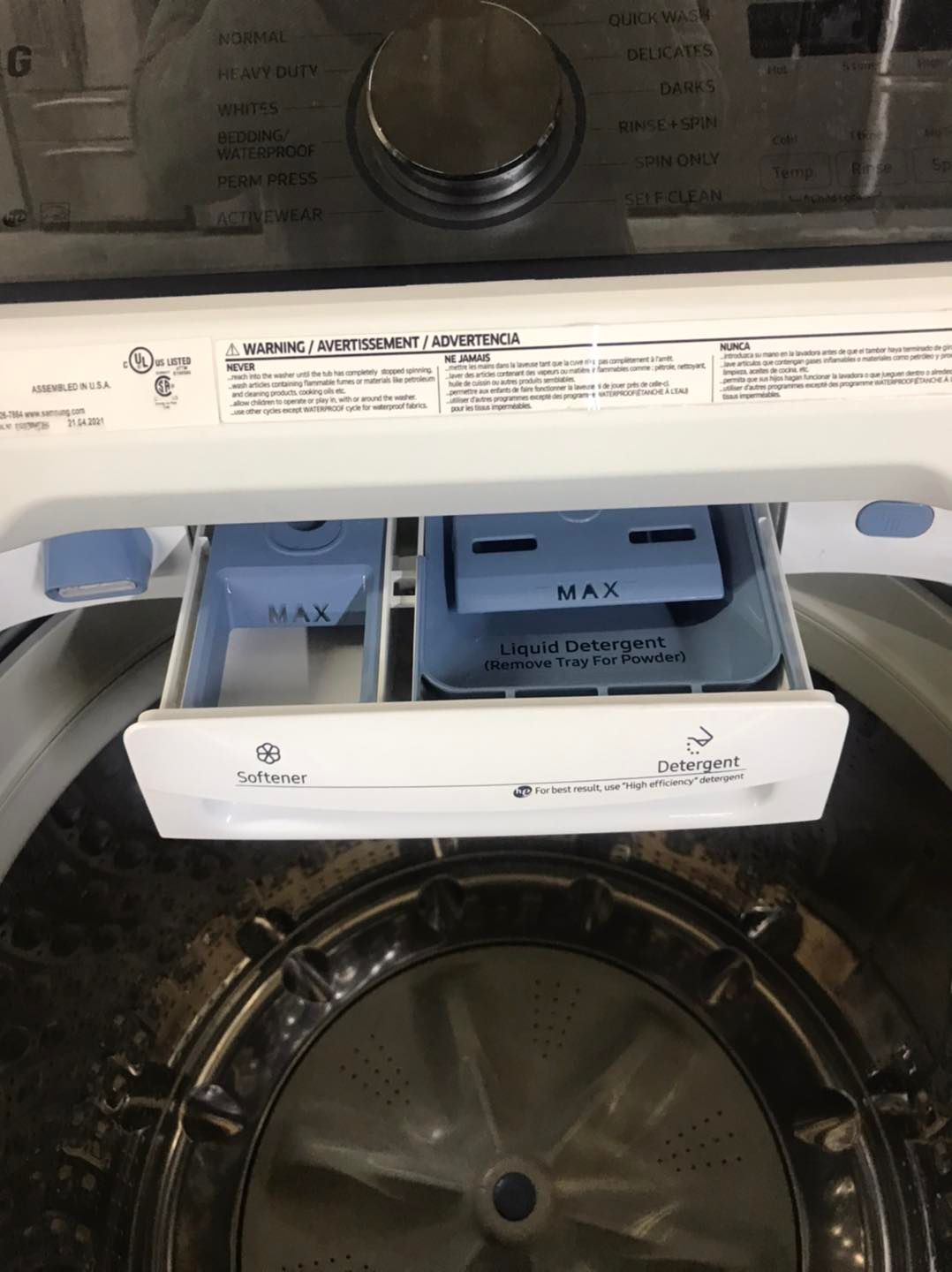 Open washing machine with detergent dispenser drawer.