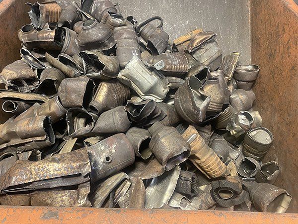 A pile of scrap metal is sitting in a wooden container.