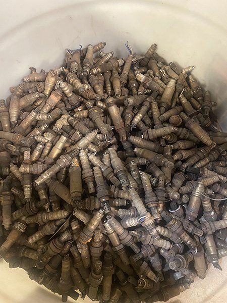 A white bowl filled with a pile of screws and nuts.