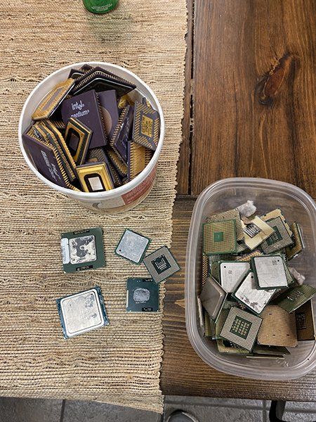 A bowl of cpu 's is sitting on a wooden table next to a plastic container of cpu 's.
