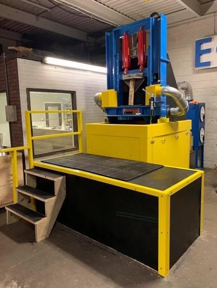 A blue and yellow machine with stairs leading up to it