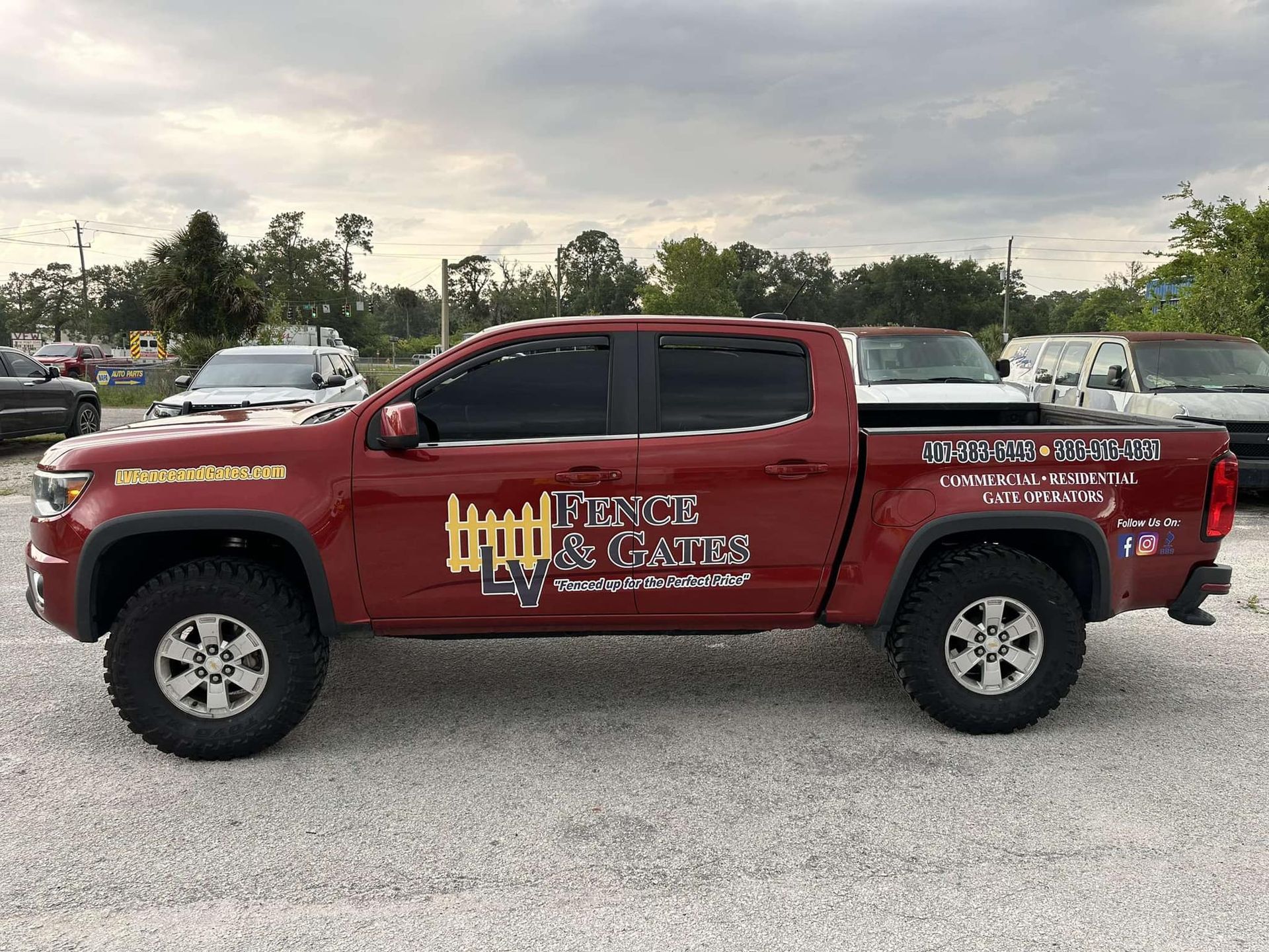 Red pickup truck with company logo on the side parked outdoors. The logo reads 