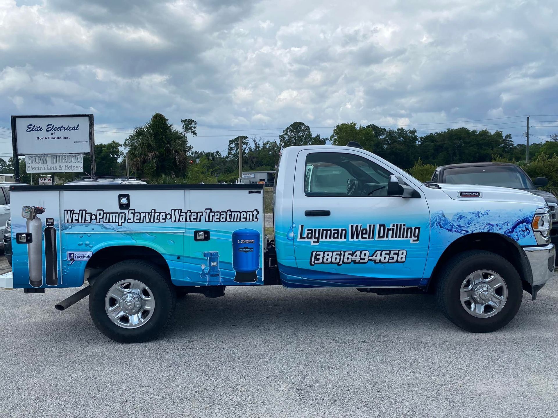White pickup truck with blue water graphics and the text 