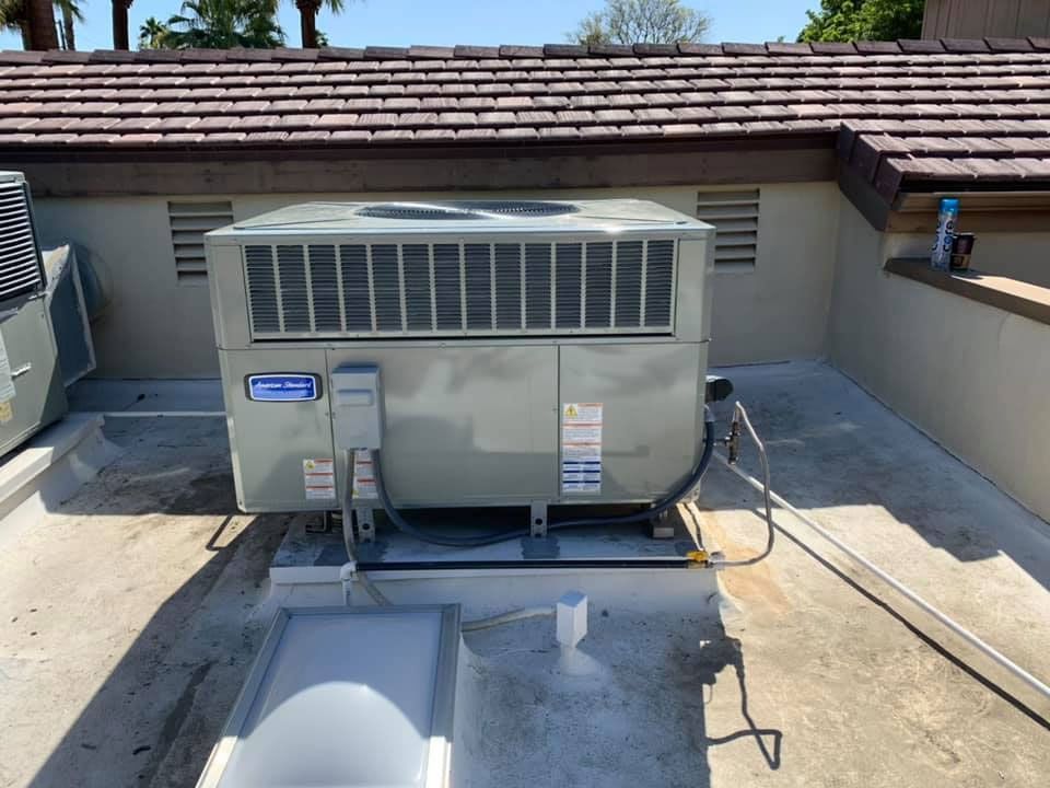 A large air conditioner is sitting on top of a roof.