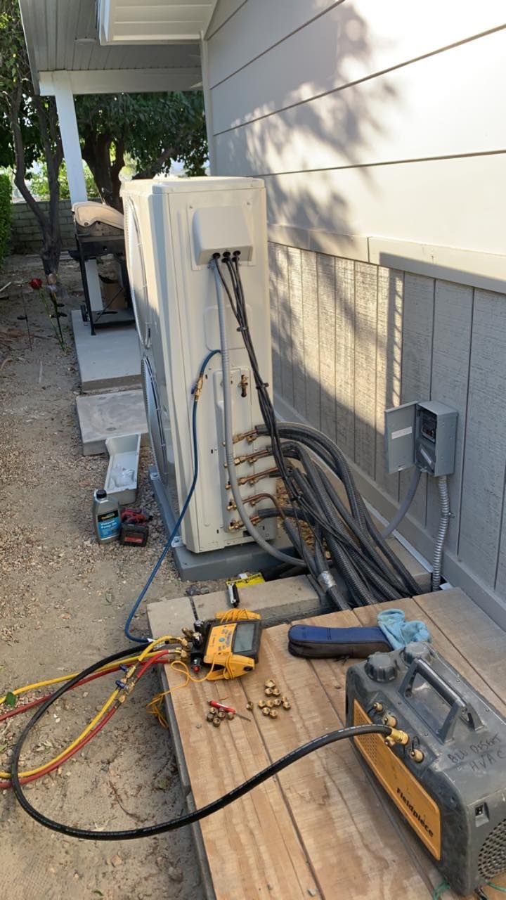 An air conditioner is being installed on the side of a house.