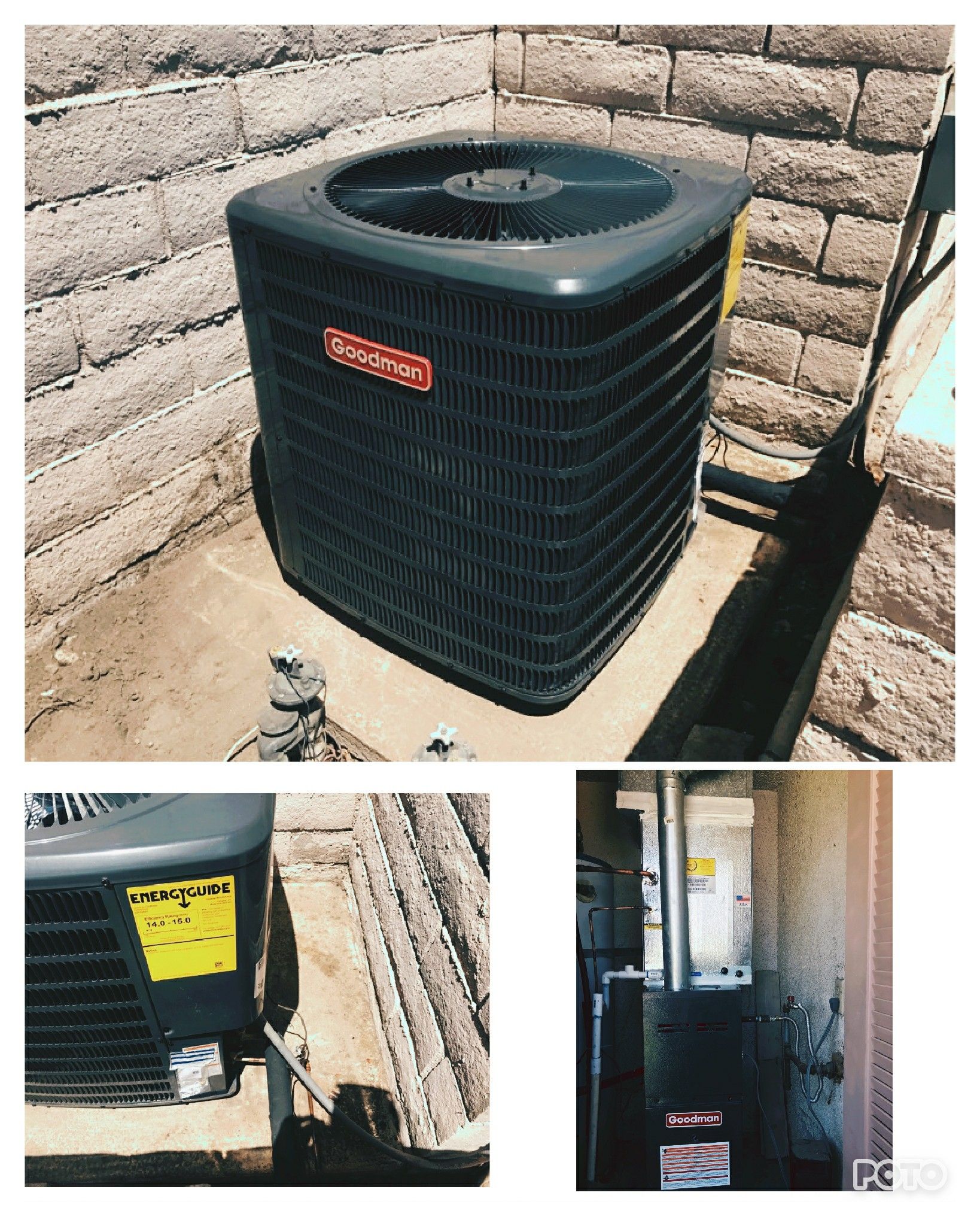 A black air conditioner is sitting next to a brick wall.