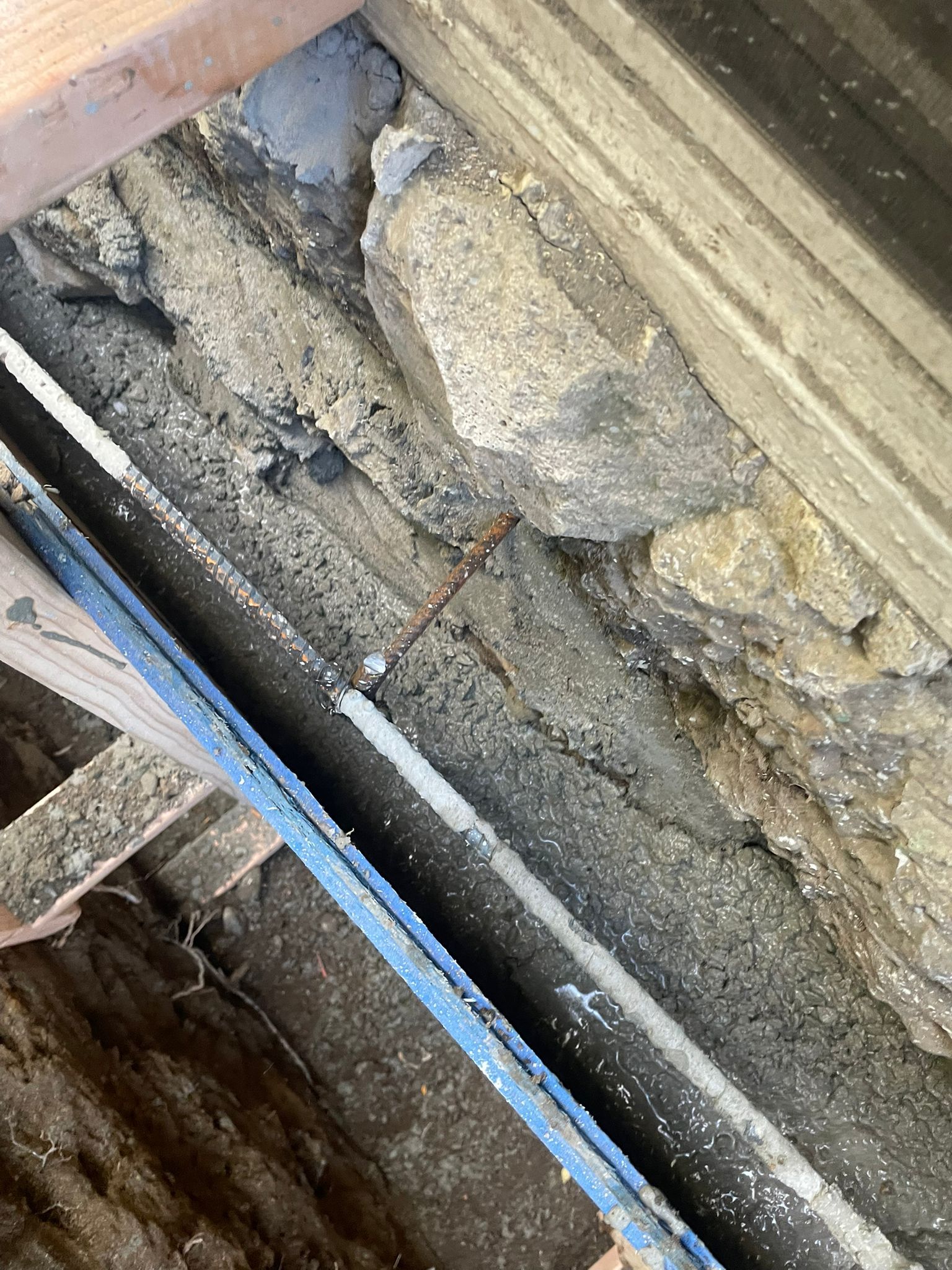 Close-up of weathered stone and wood construction with a blue strip.