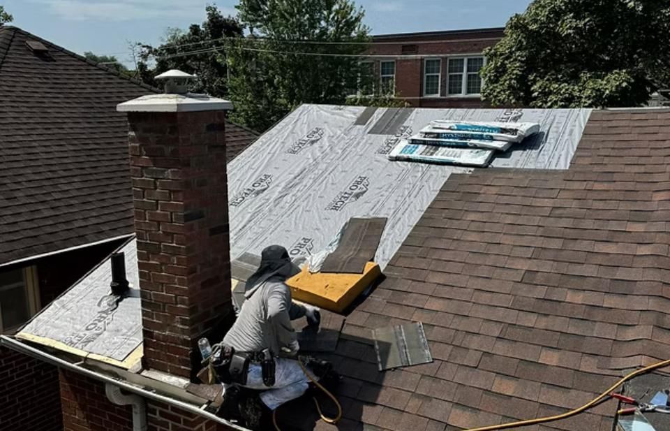 Roofer on a house roof partially covered in new shingles and underlayment, near a brick chimney.