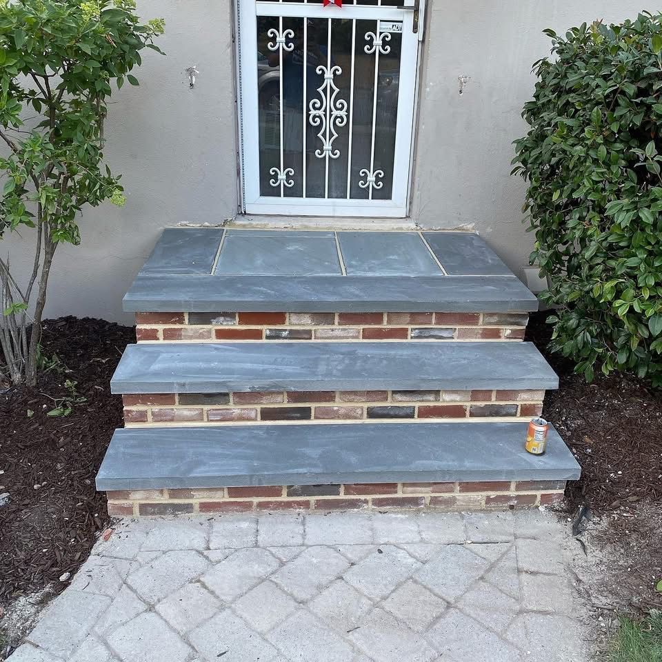 Brick and stone steps leading up to a door with a security gate.