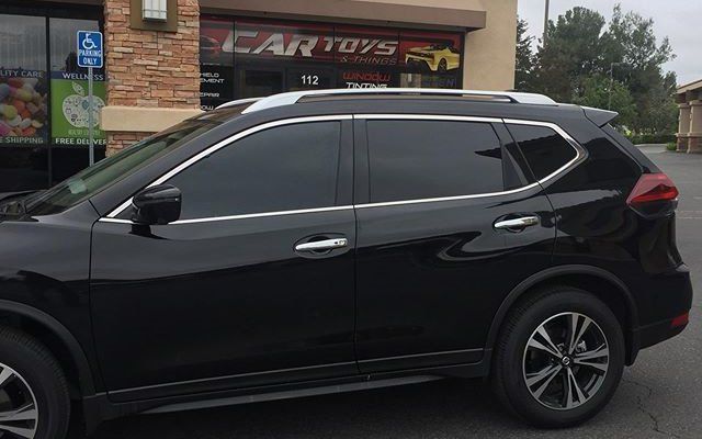 A black suv is parked in front of a car toys store.