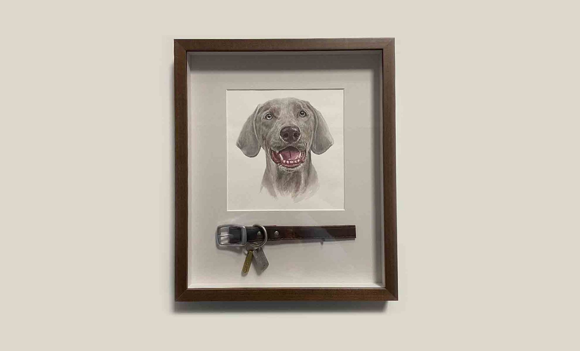 A framed picture of a dog with a collar and keys.