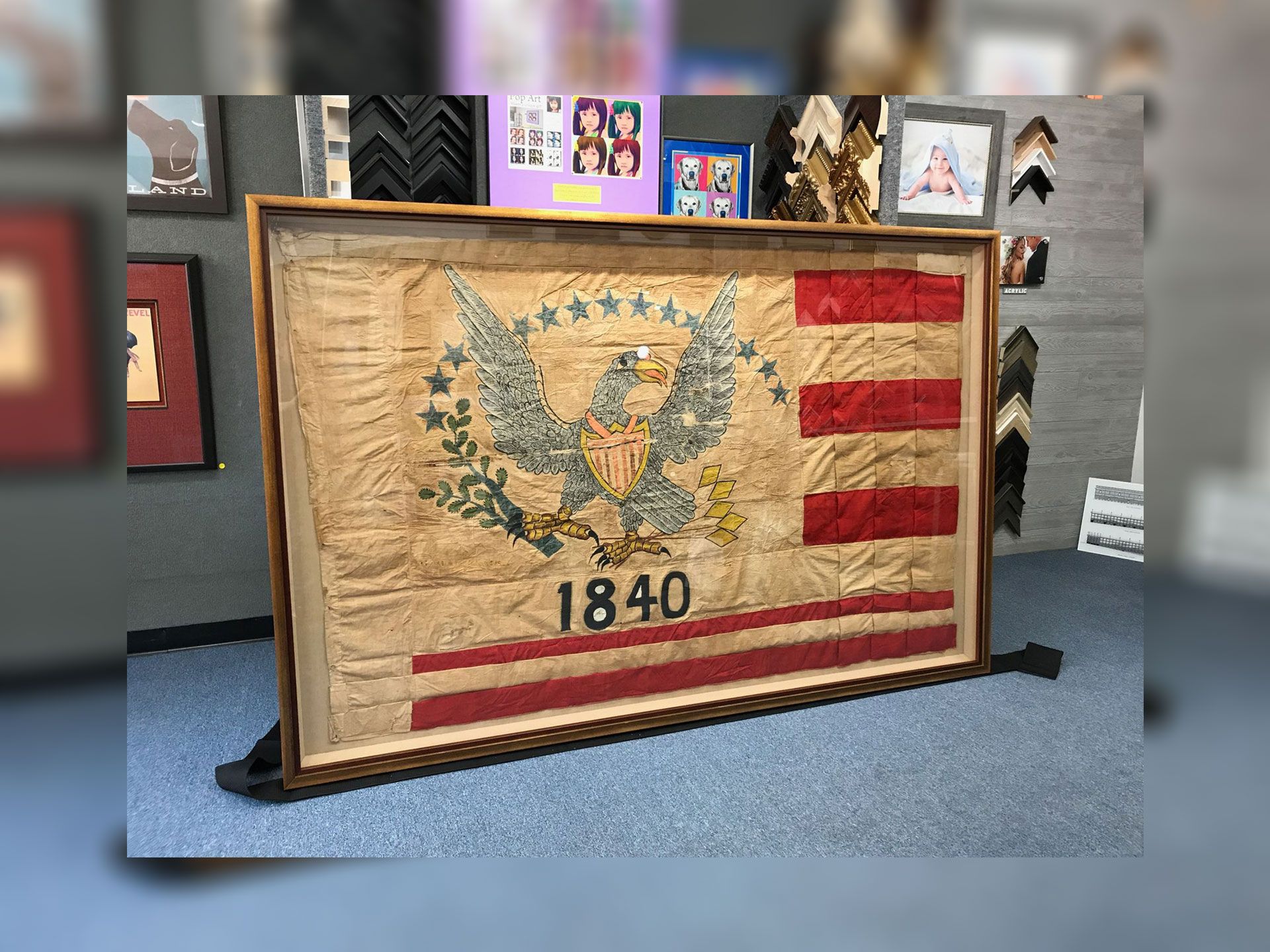 A large framed american flag is sitting on a table.