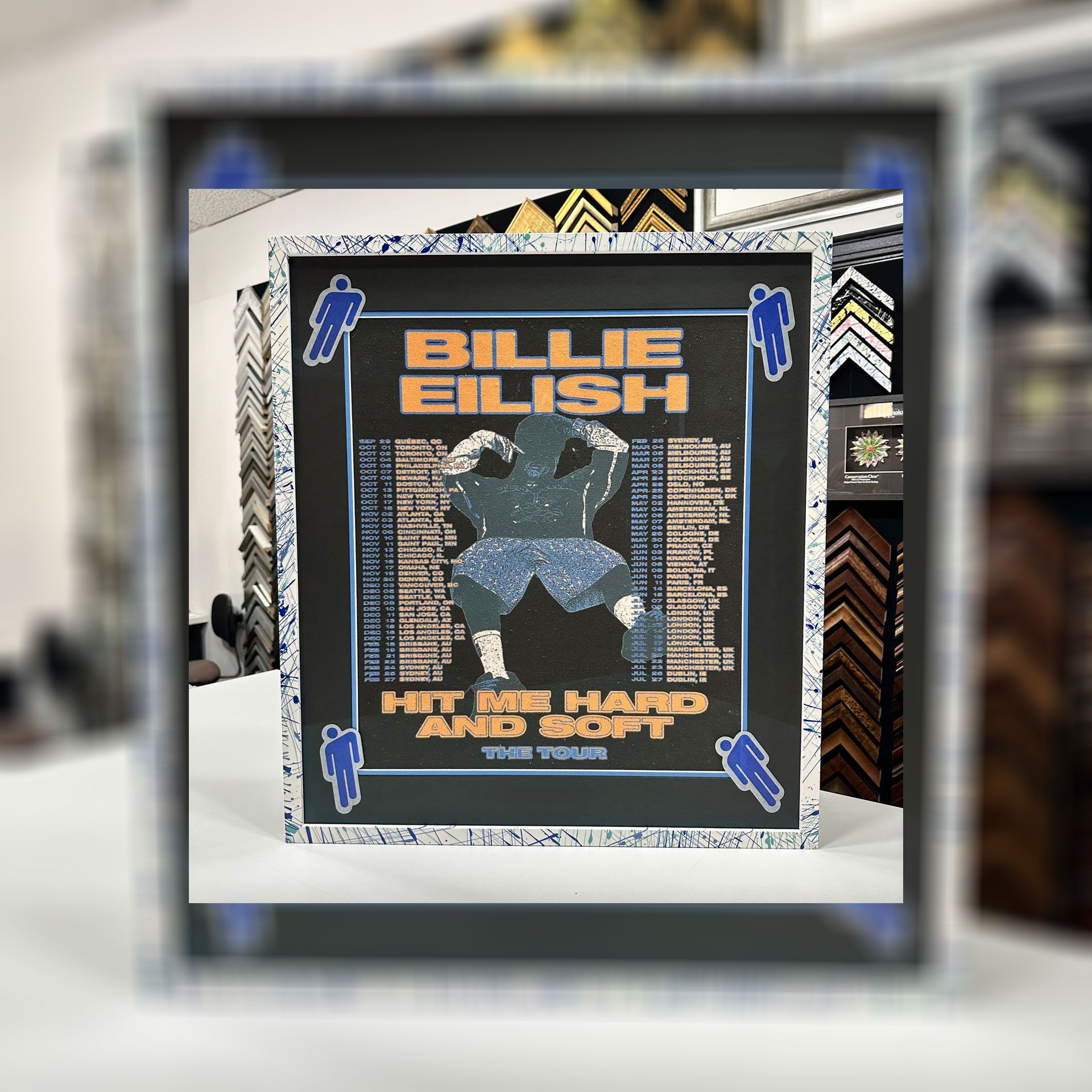 A framed billie eilish poster sits on a table