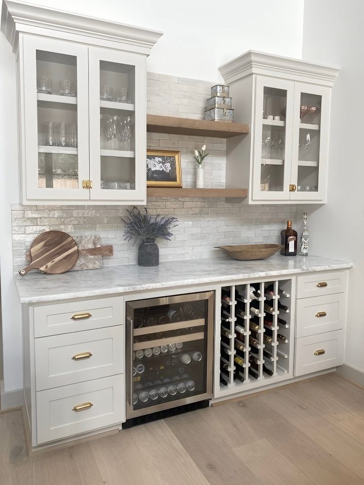 A kitchen with white cabinets and a wine cooler.
