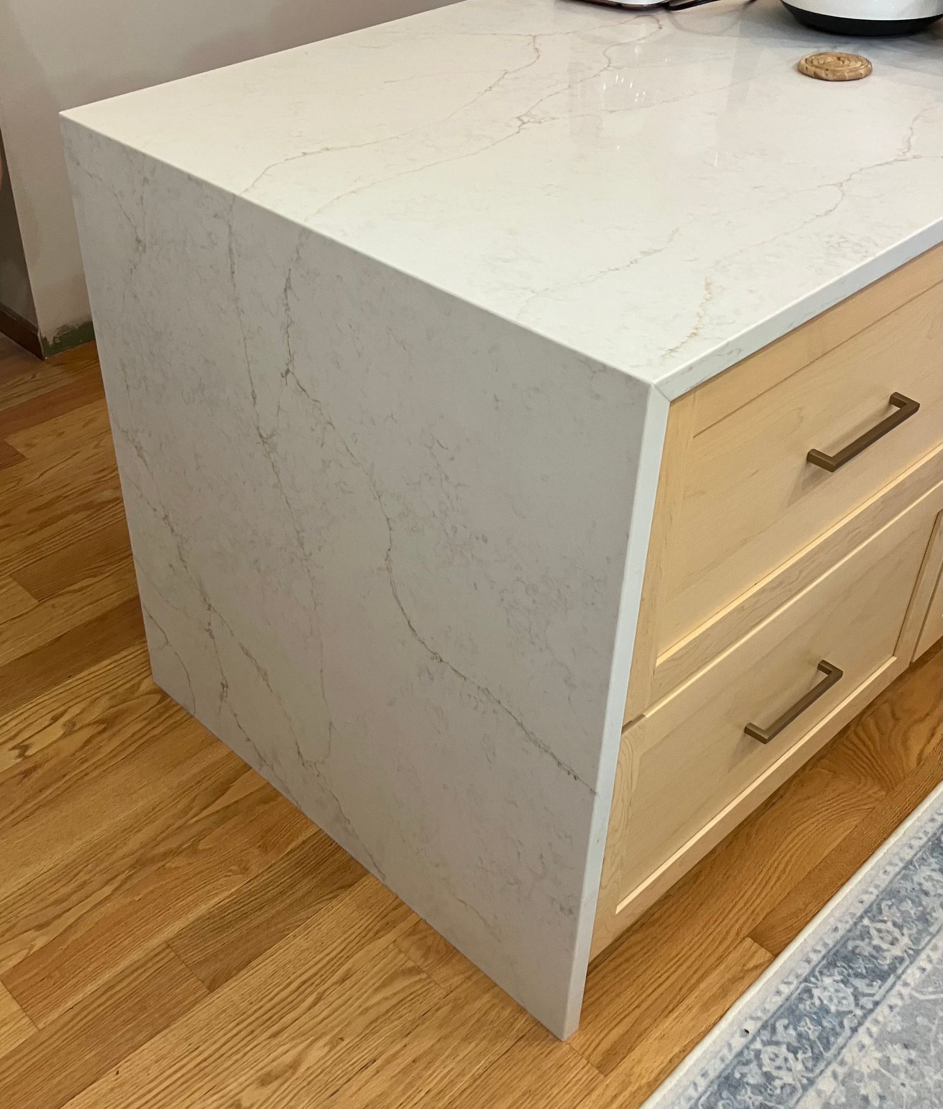 White kitchen island and light wood drawers on a hardwood floor