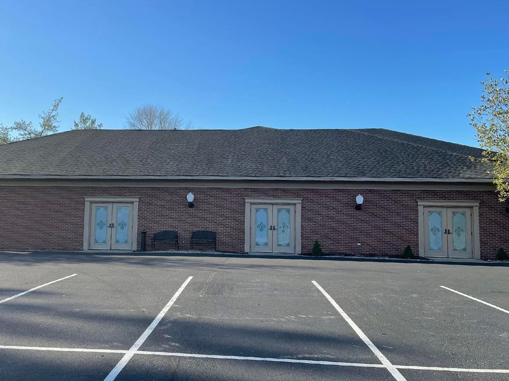 A large brick building with a parking lot in front of it.