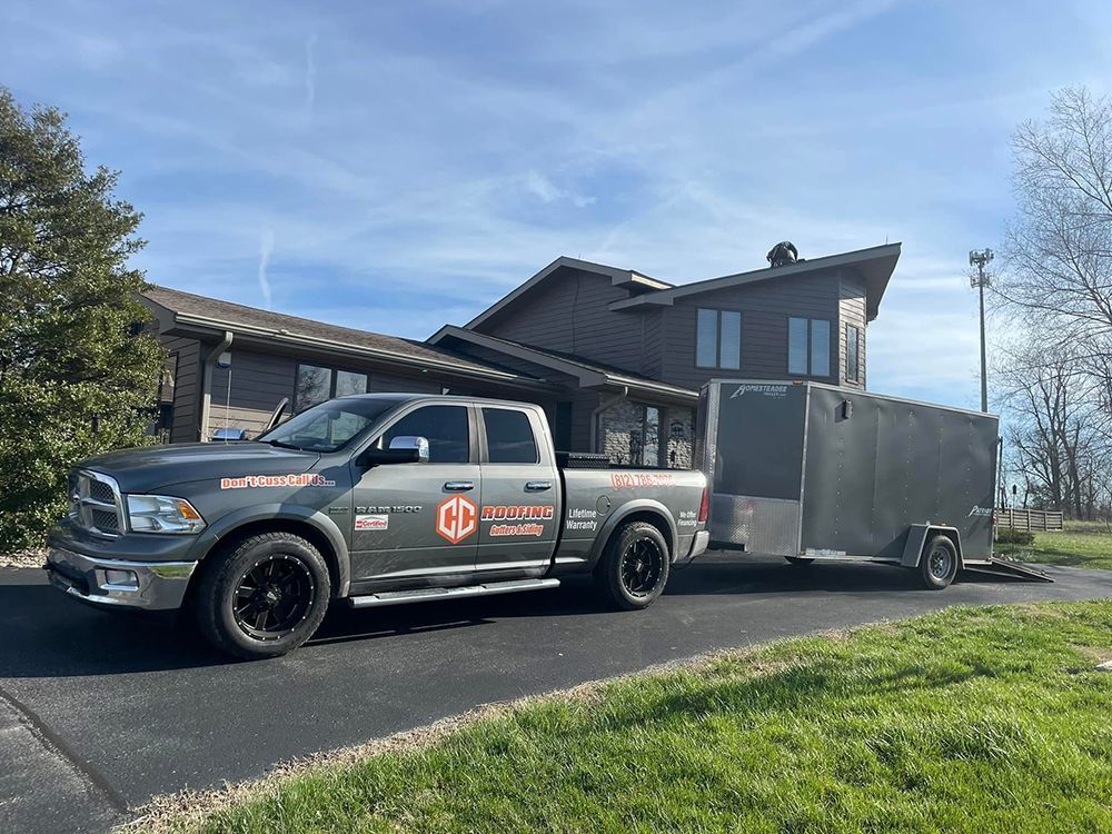 A truck with a trailer attached to it is parked in front of a house.