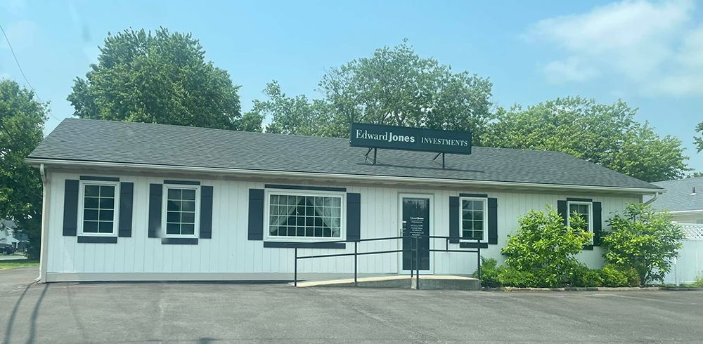A white house with black shutters and a sign that says i loved jesus