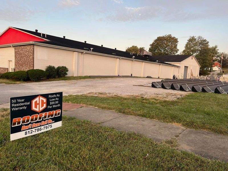 A large building with a red roof and a sign in front of it.