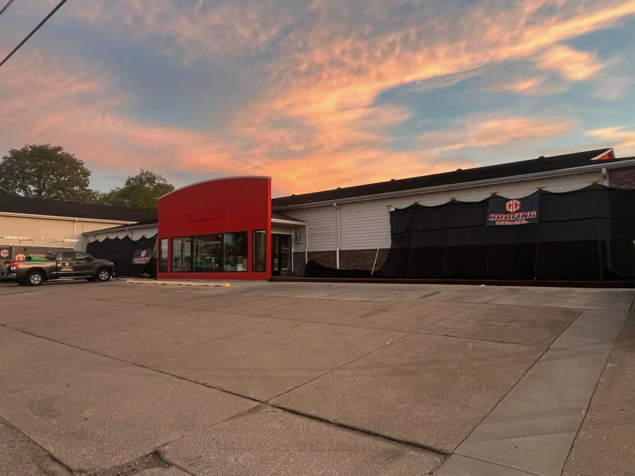 A red and white building with a sunset in the background