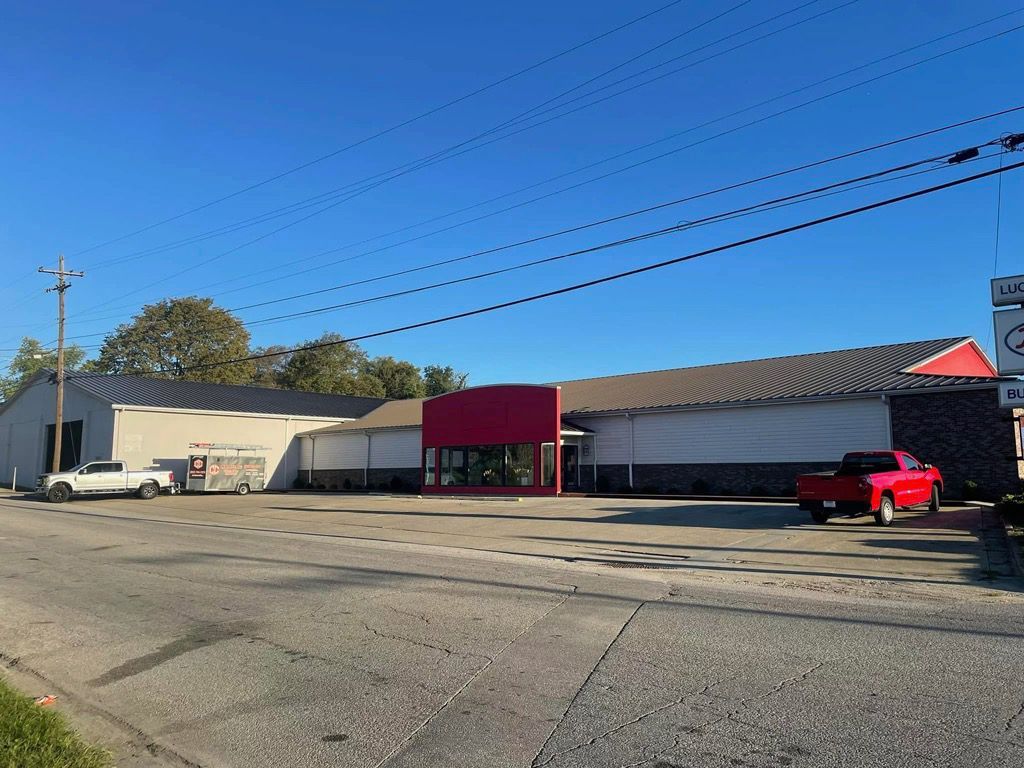 A red truck is parked in front of a building.