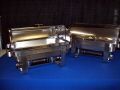 Two stainless steel chafing dishes are sitting on a blue table.